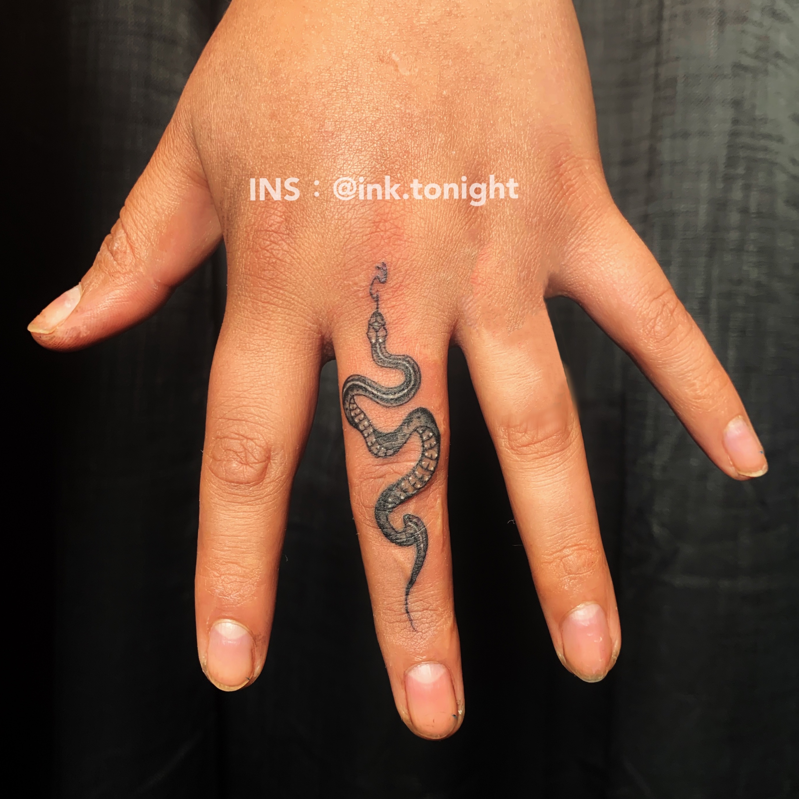 small snake tattoo on hand